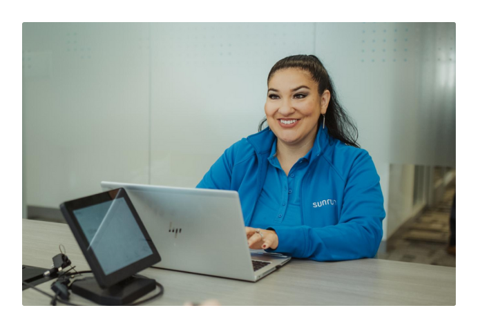 Employee smiling, working on laptop