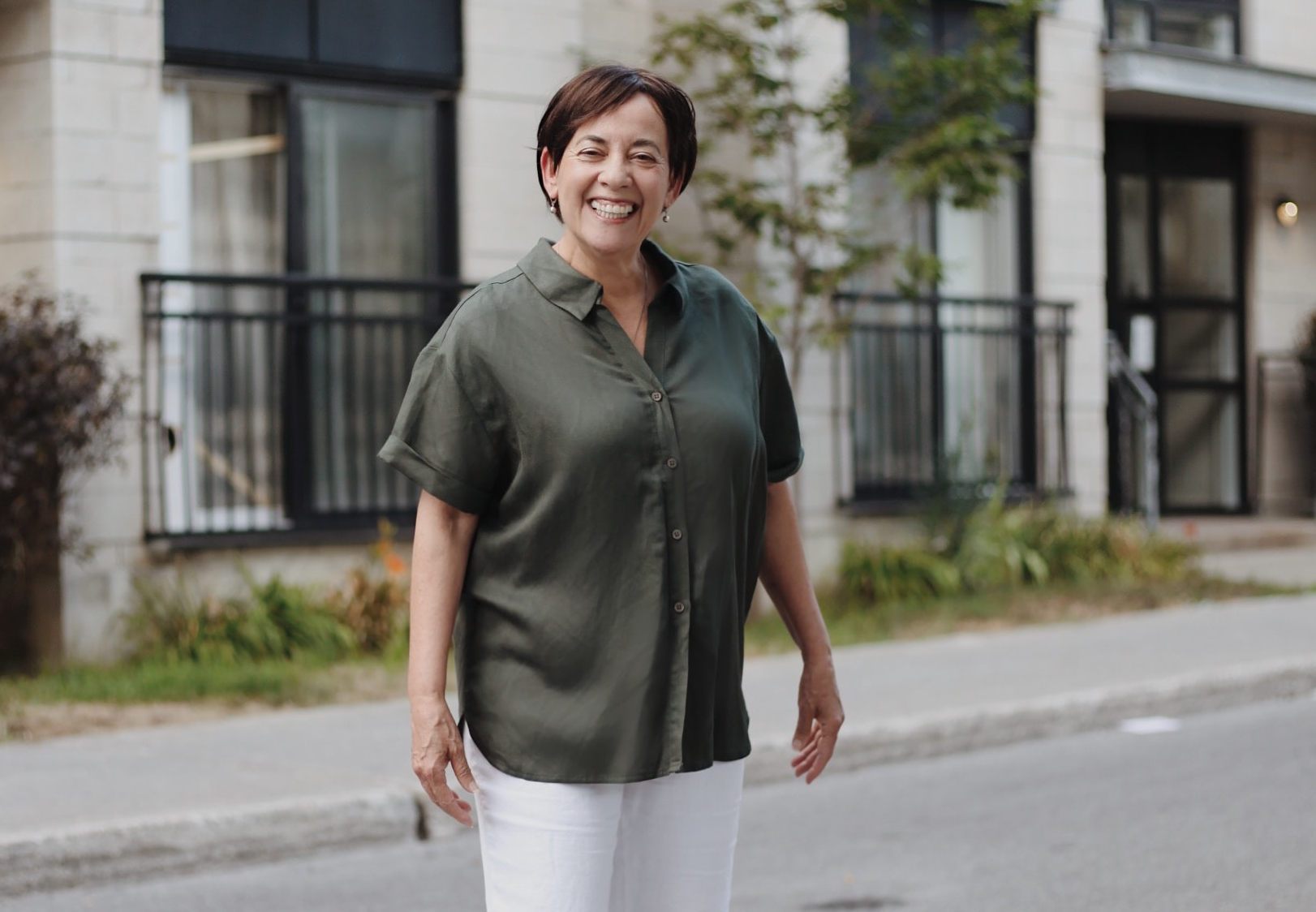 Woman standing in her neighborhood and smiling