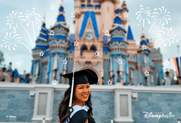 Woman smiling in graduation cap in front of Disney castle